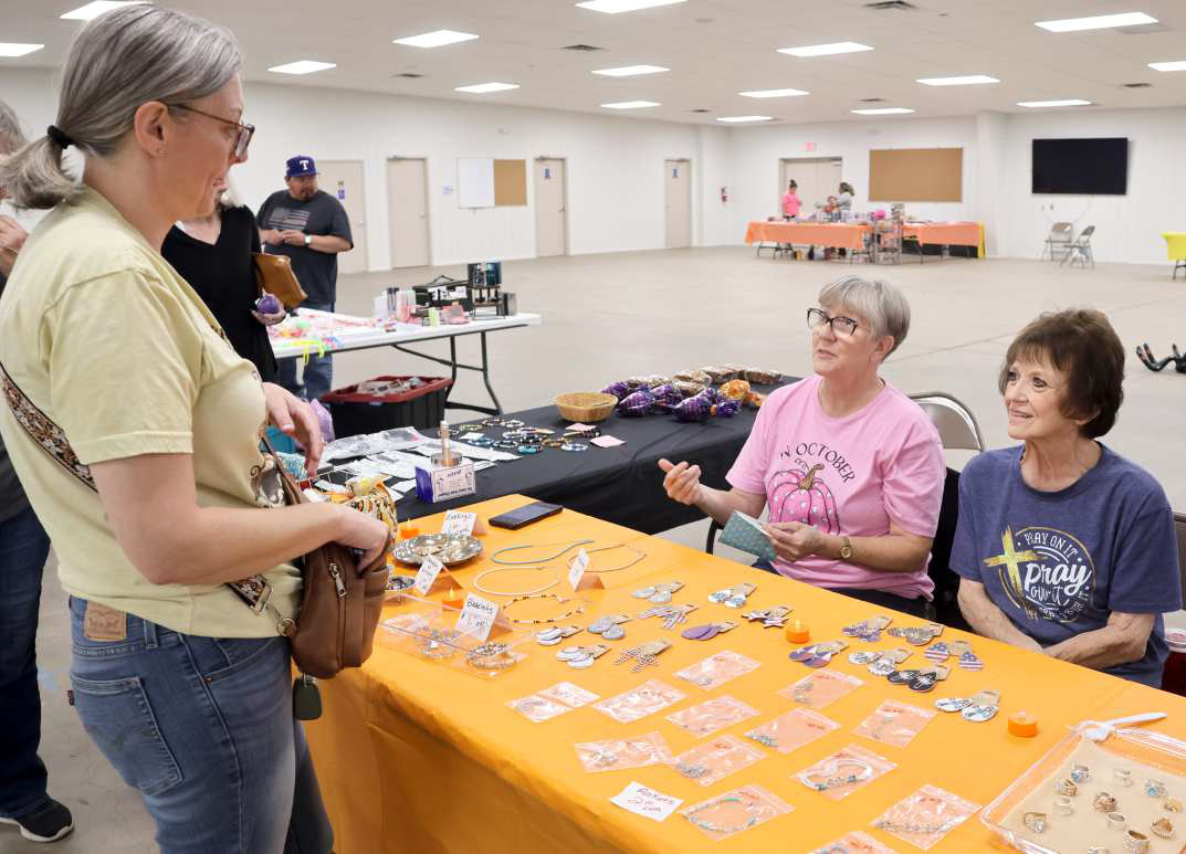 Kelly Bownds shops Rada Cutlery &amp; More manned by Sharrise Johnson and Kathy Crawford of Levelland at the Littlefield Trade Day at the Lamb County Ag Center on Saturday, October 12, 2024. (Photo by Ann Reagan)