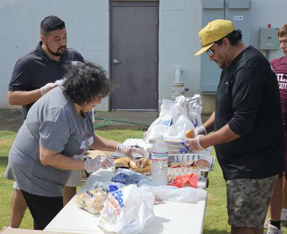 Members of the Littlefield Booster Club helped prepare burgers and hot dogs that were donated by United Supermarkets in Littlefield for the football team and coaches, after the Intersquad scrimmage on Saturday at Wildcat Stadium. (Staff Photo by Derek Lopez)