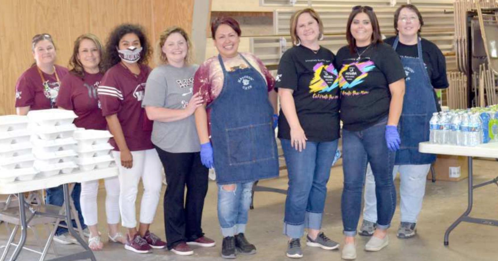 FRONT DOOR DELIVERY—These members of the Littlefield Band Boosters worked the front door of the Lamb County Ag and Community Center Friday afternoon, Oct. 9, 2020, delivering the Barbecue Meal to drive-thru families and groups, so they wouldn’t have to leave their cars. They were having a very good time, with a lot of laughter between the volunteers just before they paused for this photo. (Staff Photo by Joella Lovvorn)