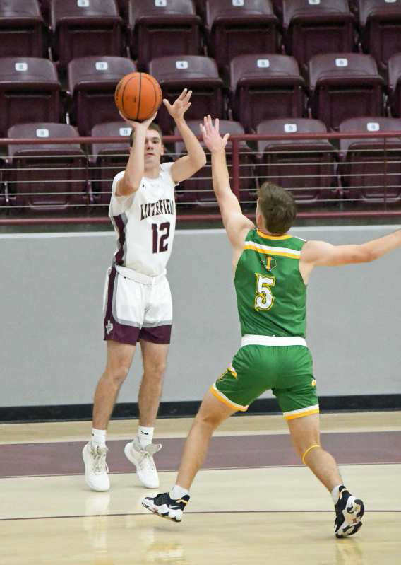 Chip Green (12) fires up a three from the right wing over Idalou’s Tate Hendley (5), during the first half of the Wildcats’, 58-52, victory at Wildcat Gym in Littlefield on Tuesday. (Staff Photo by Derek Lopez)