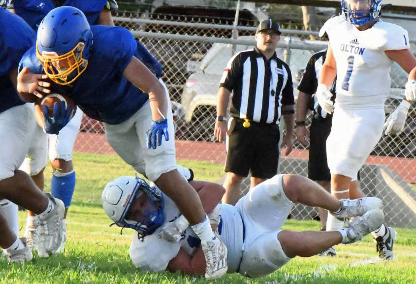Olton’s Avery Gracia wraps up the leg of the Hale Center ball carrier in the backfield for a loss on the goal line, during the Mustangs’ scrimmage with the Owls on Thursday at Owl Stadium. (Staff Photo by Derek Lopez)