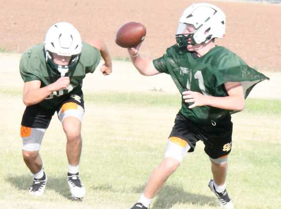 S-E senior quarterback, Slade Beerwinkle, pitches the ball back to his back, during team offensive drills on Thursday, during their twoa- day practice. (Staff Photo by Derek Lopez)