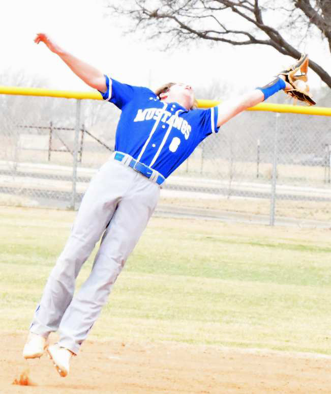Olton’s Jett Tomsu fights the wind on a high fly ball and makes a tough catch at second base, during the Mustang’s Lamb County Classic-opener against Ropes on Thursday morning. (Staff Photo by Derek Lopez)