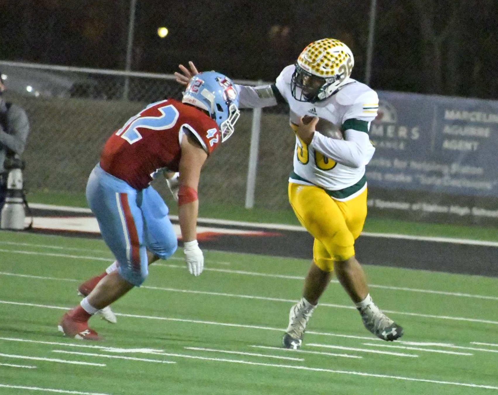 FIGHTING FOR YARDS — Springlake-Earth junior full-back, Keshan Holmes, stiff arms a Borden County defender, on his way to a solid gain, during the Wolverines, 71-16, Regional round play-off loss to the Coyotes at Slaton on Friday. (Staff Photo by Derek Lopez)