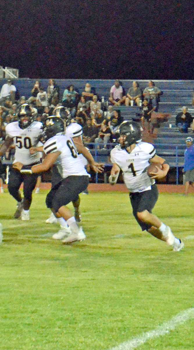 LOOKING FOR A HOLE - Sudan junior quarterback, Trent Wilson (1), carries the ball for the Hornets, during the second half of their, 49-0, loss to the Olton Mustangs on the road on Friday night. (Staff Photo by Samantha Pontius)