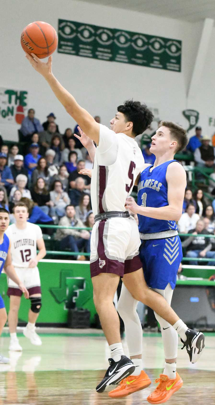 Littlefield senior, Jeremiah Trevino (5), gets by Childress’ Aiden Allen for a lay-up, during the first half of the Wildcats’ Area Championship game against Childress on Friday at Floydada High School. The Wildcats would come up just short in the contest bringing their season to a close. (Staff Photo by Derek Lopez)