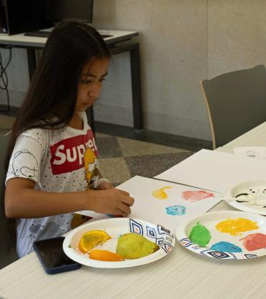 The Library continued its Creative Sprouts camp on July 16. This week’s lesson focused on the sense of taste, and attendees created paintings using dyed yogurt and fruits as stamps. (Staff Photos by Madison Vidales)