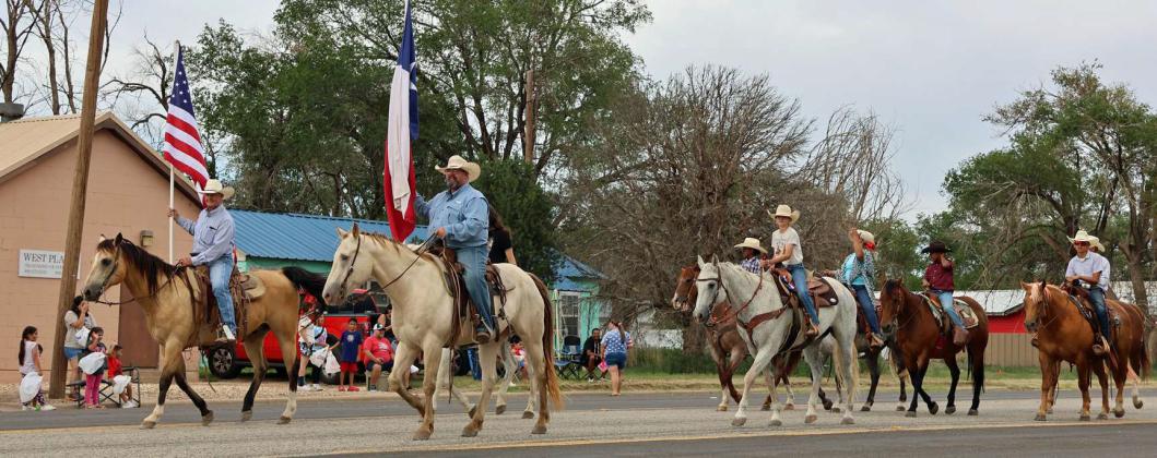 The U.S.A. and Texas flags made their way down the road via horseback to open the Springlake 4th of July Parade on Thursday. (Photo by ann Reagan)