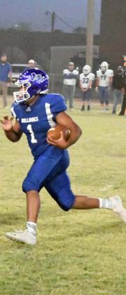 CARRYING THE BALL – Amherst senior tailback, Omar Reyes Jr., carried the ball around the left side, following a lead block from junior, Chris Gonzales, during the Bulldogs, 74-31, victory over Claude on Thursday night. (Staff Photo by Derek Lopez)