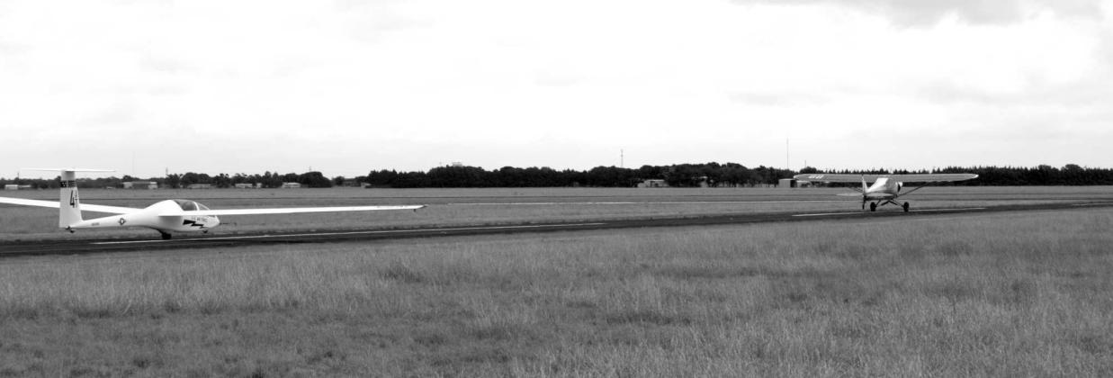 A specialized tow plane pulls a U.S. Air Force TG15A glider down the runway, beginning a training flight designed to teach cadets the fundamentals of unpowered flight. (Photo by Leon Szaniszlo)
