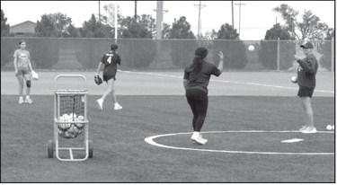 Assistant Coach Suzanne Perry works with campers during drills at the Littlefield Youth Softball Camp on June 18 at the Lady Cat Softball Field in Littlefield.