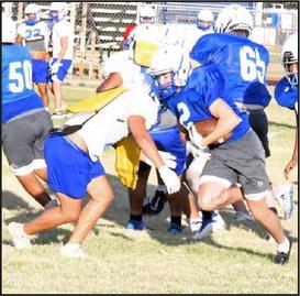 An Olton JV ball carrier takes a hand-off up the middle, but he is stuffed at the line by a defender, during the Mustang’s intersquad scrimmage on Saturday. (Staff Photo by Derek Lopez)