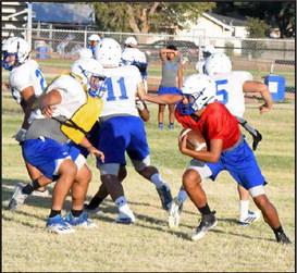 Olton varsity quarterback, Raymond Ramirez pulls the ball from his running back for a quarterback keeper to his left, during the Mustang’s intersquad scrimmage on Saturday. (Staff Photo by Derek Lopez)