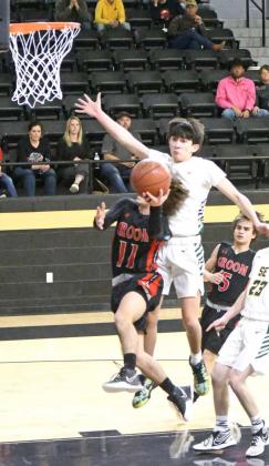 DELIVERING THE BLOCK— Springlake-Earth junior guard, Evan DeLeon, delivers a block on Groom’s Damon Kuehler, during the first half of the Wolverine’s lAArea Play-off game against the Tigers on Tuesday at Vega High SchooL (Staff Photo by Derek Lopez)
