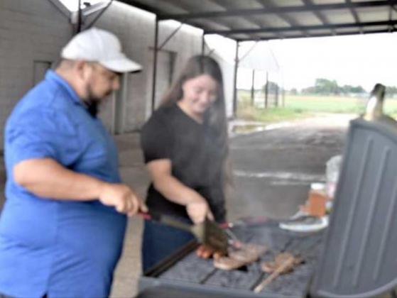 GRILLING FOR PROGRAM -- Jerry Sanchez and BriAnn McKinnerney man the grill for the Lamb County Library end of program celebration. (Photo by Ann Reagan)