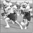 A Sudan ball carrier follows his blocker for a run up the middle, during their intersquad scrimmage Saturday night at Hornet Stadium. (Staff Photo by Derek Lopez)