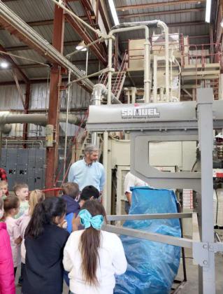 The second graders of Sudan ISD watch the finished ginned cotton go into the baling machine during the tour of the facility.
