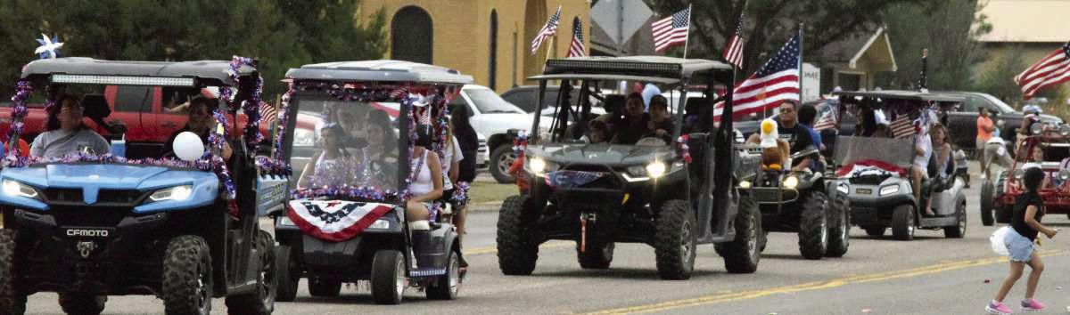 Families ride through the Springlake Fourth of July parade on ATVs, waving to spectators lined along the roadside during the annual fundraiser for the Springlake Volunteer Fire Department. (Photo by Leon Szaniszlo)
