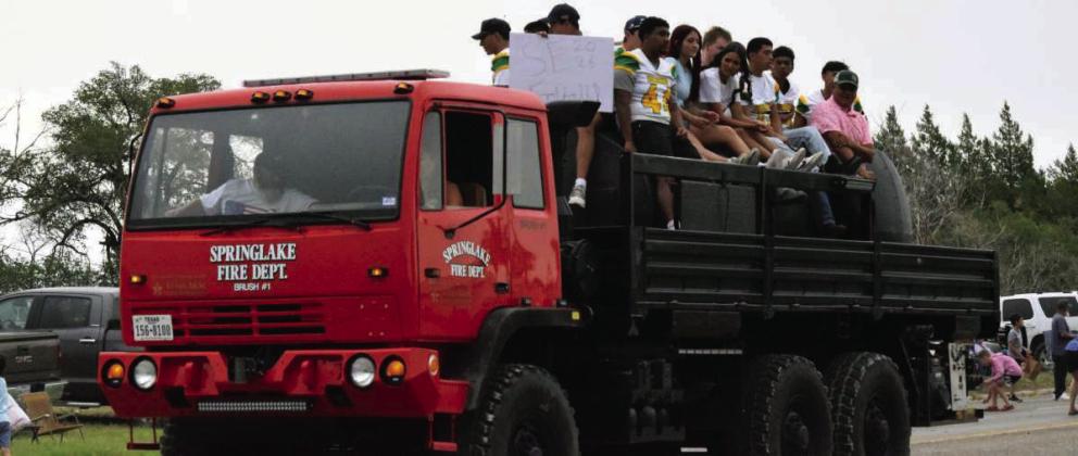 Members of the Springlake-Earth ISD football team ride on a fire truck during the Fourth of July parade. (Photo by Leon Szaniszlo)