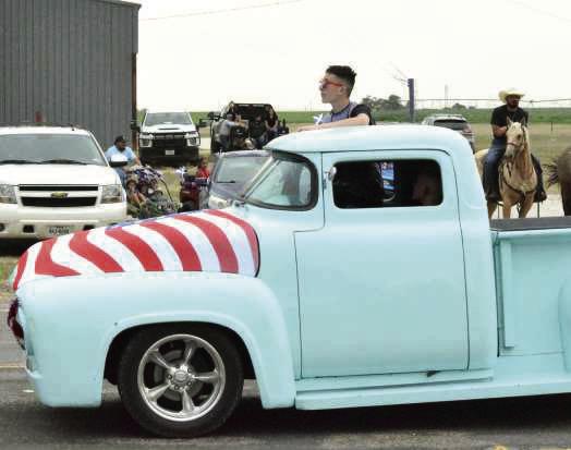 A vintage pickup drives through the Springlake Fourth of July parade as kids pick up candy along the roadside. (Photo by Leon Szaniszlo)