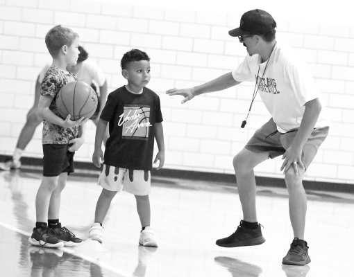 Olton Mustang Varsity Asst. Coach Rosario Gonzalez explains a defensive drill to some campers, during their first day on Monday, May 25. (Staff Photo by Derek Lopez)
