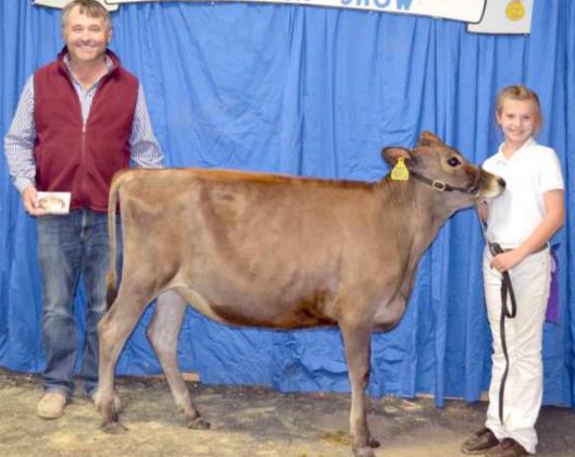 GRAND CHAMPION DAIRY HEIFER, a Jersey, was exhibited by Ava Van de Pol of Sudan. They are shown with the Dairy Show Judge, K.R. Averhoff. (Staff Photo by Joella Lovvorn)