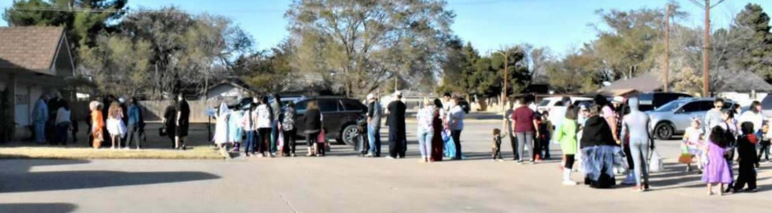 LONG TRICK OR TREAT LINE AT HILLCREST FUNERAL HOME Saturday evening, some social distancing was observed on the parking lot of Hillcrest Funeral Home, as parents and their children were waiting for the line to get shorter so they could receive their treats. The groupings shown are more than likely families, that are together most of the time, anyway. (Photo by Krista Carpenter)