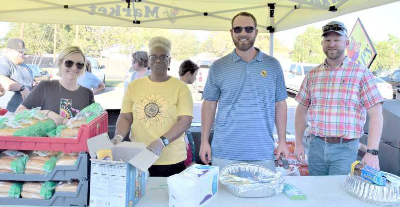 HOLLY NELSON, Kandy Scales, Reese Rogers and Eric Turpen of the Littlefield Chamber of Commerce serve hot dogs at the Littlefield Aquatic Center Splash Bash Back to School Party Thursday. (Photo by Ann Reagan)