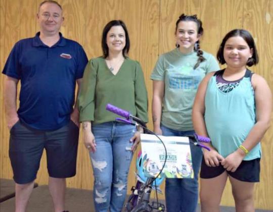 BICYCLE WINNER -- left to right - Kasey and Vanna Wright of Wright Collision Center, Victoria Dennis, and first place prize winner ages 7 to 9, Emma Salinas. (Photo by Ann Reagan)