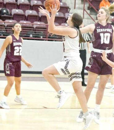 GETTINGINSIDE -Littlefield froshman,KyndalEdgemon (24), cuts through traffic and gets into the lane for a lay-up, during the first half of the Lady Cats’, 52-40, loss to the Lady Whitefaces on Tuesday at Wildcat Gym. (Staff Photo by Derek Lopez)