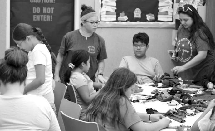 Attending kids work on handmade dog toys to donate to the Littlefield Animal Shelter on July 23 during a program at the Lamb County Library, held in honor of National Craft for Your Local Animal Shelter Day. (Photo by Leon Szaniszlo)