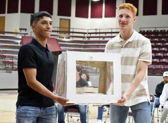 Littlefield’s, Gabe Montalvo and Sam Hill, display their cake, while Auctioneer Guyle Roberson auctions it off during the 2023 LHS Cake Auction that took place Friday morning at Wildcat Gymnasium. (Staff Photo by Derek Lopez)