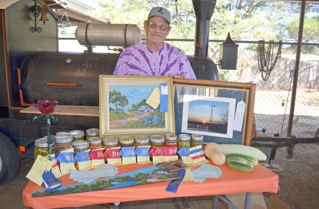 DELMAR WHITE poses with 15 of his 18 ribbons he won in the South Plains Fair. He won first and second places for canned goods such as green beans, pickled okra, black eyed peas and more. He won three white ribbons, not photographed, for his vegetables. He also won blue ribbons for two paintings his wife created. (Staff Photo by Samantha Pontius)