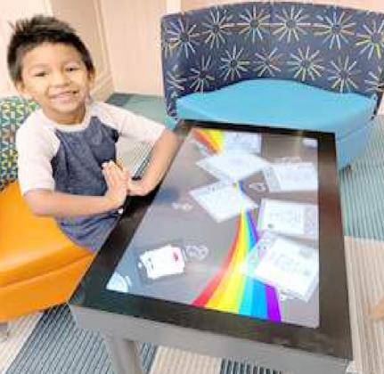 EXCITED ABOUT TOUCH TABLE – This youngster was seated at the new Interactive Touch Table, and looks as if he doesn’t know where to start with this game. It is one of 14 new built-in games for children to play at the Lamb County Library in Littlefield. He was probably helped to learn what to do, to play. (Lamb County Library Photo)