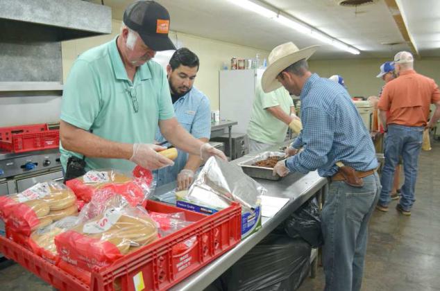 PRE-GAME MEAL - The Littlefield Masonic Lodge hosted a pre-game meal at the Lamb County Ag Center on Friday following the pep rally at the High School for the “War on 84” Football game with Muleshoe. Shown are members of the Masonic Lodge preparing the brisket sandwiches. (Staff Photo by Samantha Pontius)