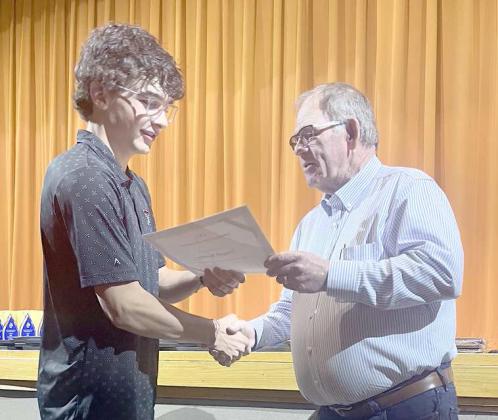 Third Place recipient of Lamb Co. SWCD scholarship, Truett Kirby, was awarded at the Sudan Award assembly held at Sudan High School on Tuesday May 16,2023. Shown is Kirby receiving the $100 Scholarship from Roy Thompson. (Submitted Photo)
