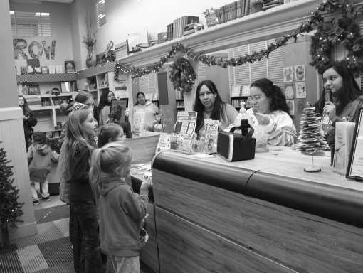 Folks wait to see if they hear their names called during the drawing for free door prizes at the Lamb County Library, during the Christmas Bash that was held on Dec. 12. (Photo by Ann Reagan)