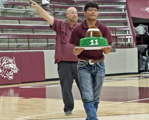 Zane Champion shows off his cake at the 2025 LHS Cake Auction on Wednesday. (Staff Photo by Derek Lopez)
