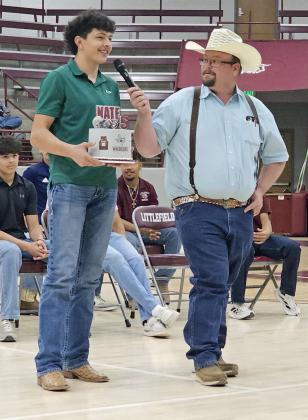 Nate Castaneda describes his cake to the auctioneer at the 2025 LHS Cake Auction on Wednesday. (Staff Photo by Derek Lopez)