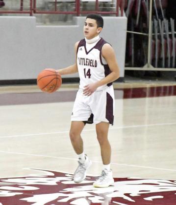 BRINGING THE BALL UP—Littlefield senior point guard, Jeremiah Salazar (14), brings the ball across half court looking to set up the offense, during the first half of the Wildcats’ victory over the Roughnecks on Tuesday. (Staff Photo by Derek Lopez)