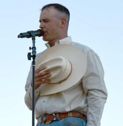 NATIONAL ANTHEM -- Will Bannister, entertainer from Portales, NM, (right) opened the Annual Springlake Volunteer Fire Department 4th of July celebration by singing the National Anthem. The crowd in the Springlake park pays tribute. (Photos by Ann Reagan)