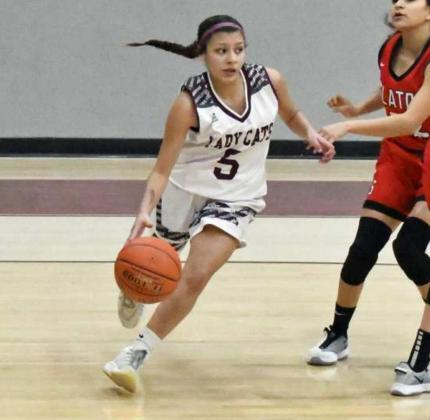 FINDING THE OPENMAN—Littlefield junior guard, Emily Champion (5), drives the left baseline and dishes the ball to Brookelyn Gau on the free-throw line, who knocked down the jumper, during the first half of the Lady Cats’, 50-34, victory over the Tigerettes at Wildcat (Staff Photo by Derek Lopez)