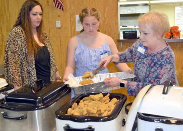 FILLING FISH WARMER – Bob Edwards’ family members, Brittany Edwards, Kinzlee Edwards, and Mechele Edwards were adding fresh cooked fish to the warmer Saturday evening, April 24, 2021, during the community’s celebration of Bob’s 88th birthday. They are some of the family members who hosted the 13th annual fish and chicken fry. (Staff Photo by Joella Lovvorn)