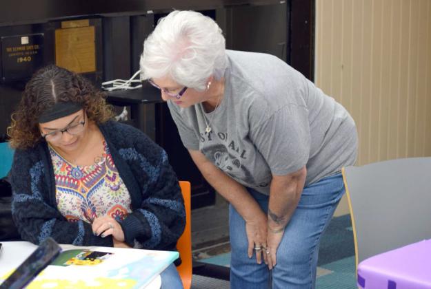 Lead instructor of Color Your Soul Paint Party Studio in Levelland, Sussan Bell, talks with Assistant Librarian Ambrosia Simpson during the Lamb County libraries’ Painting workshop on July 16. (Photo by Leon Szaniszlo)