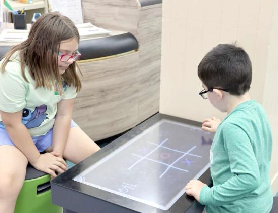 Youngsters playing Tic-Tac-Toe at the Ice Cream Social at the Lamb County Library. (Photo by Ann Reagan)