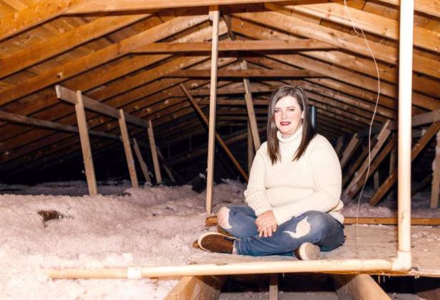 Ashley Simpson of Canyon sitting in her attic with her newly installed insulation. (Submitted Photo)