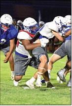 Olton’s defensive line makes a tackle behind the line of scrimmage during their Midnight Madness scrimmage Friday night. (Staff Photo by Derek Lopez)