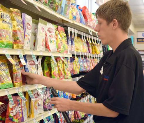 ADAM SCAFF stocks the candy shelves at United Supermarket in Littlefield. Adam is a student with the South Plains Workforce Commission in the SEAL program. (Photo by Ann Reagan)