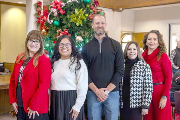 At their annual open house, Kyla Howell, Elizabeth Martinez, Bret Holloway, Ana Guerrero and Jennifer Cerbantez pose for a photo in front of the tree at Wellington State Bank Dec. 13, 2024. (Photo by Madison Validas)