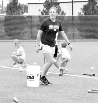 Head Coach Ally Oyanguren works with a camper on pitching mechanics during the Littlefield Youth Softball Camp on June 18 at the Lady Cat Softball Field in Littlefield.